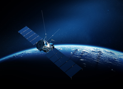 Communications satellite orbiting Earth with sunrise in space